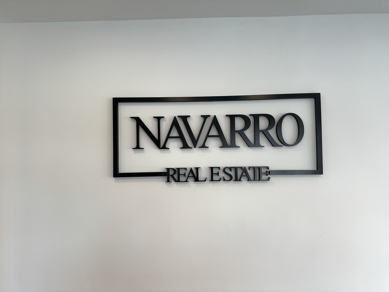 Logo de Navarro Real Estate en la oficina